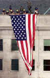 Image © Washington Post. Firemen and US Flag on the Pentagon.